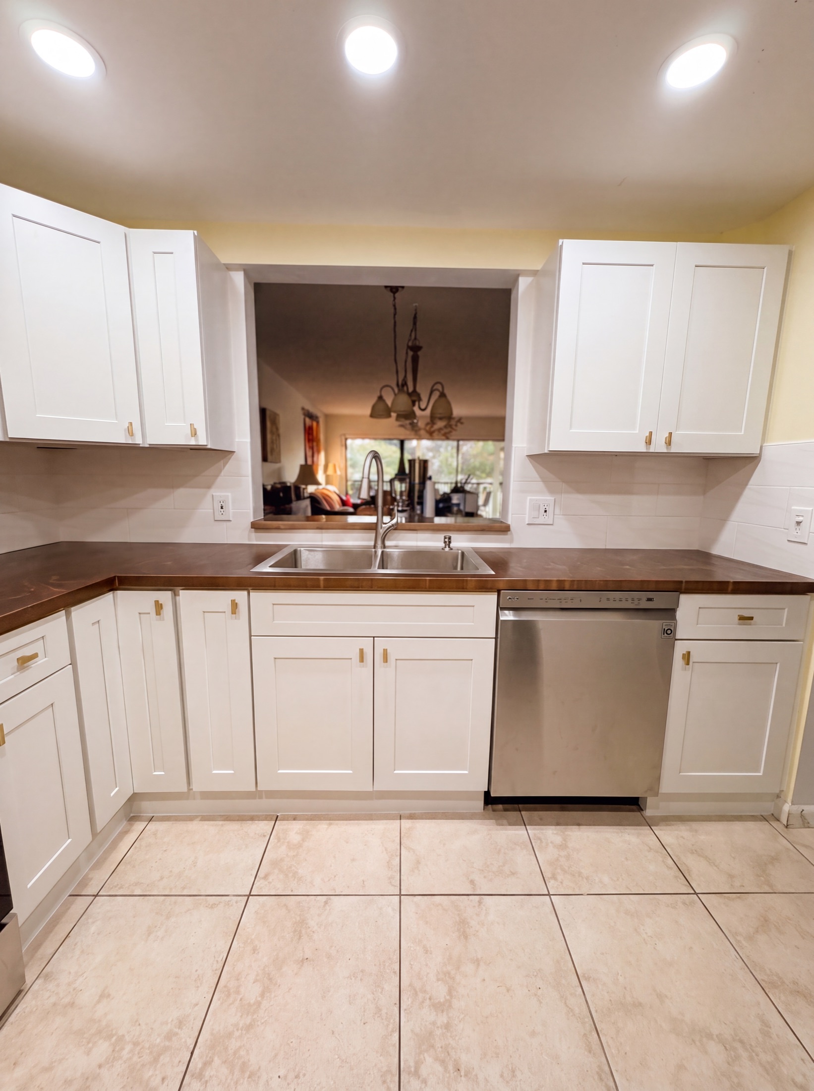 Kitchen after — crisp white shaker cabinets and subway-tile backsplash