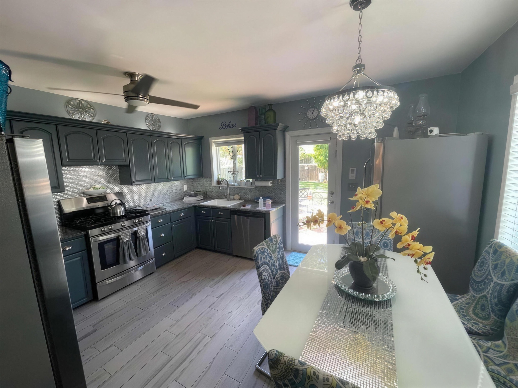 Kitchen before — dark teal arched-panel cabinets