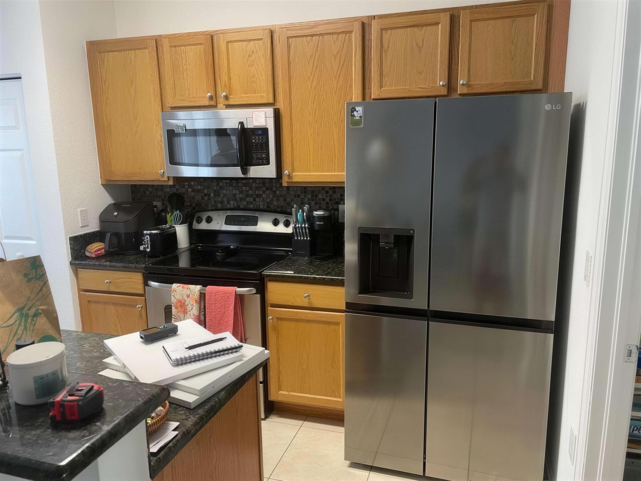 Kitchen before — honey-oak cabinets and tan tile floor