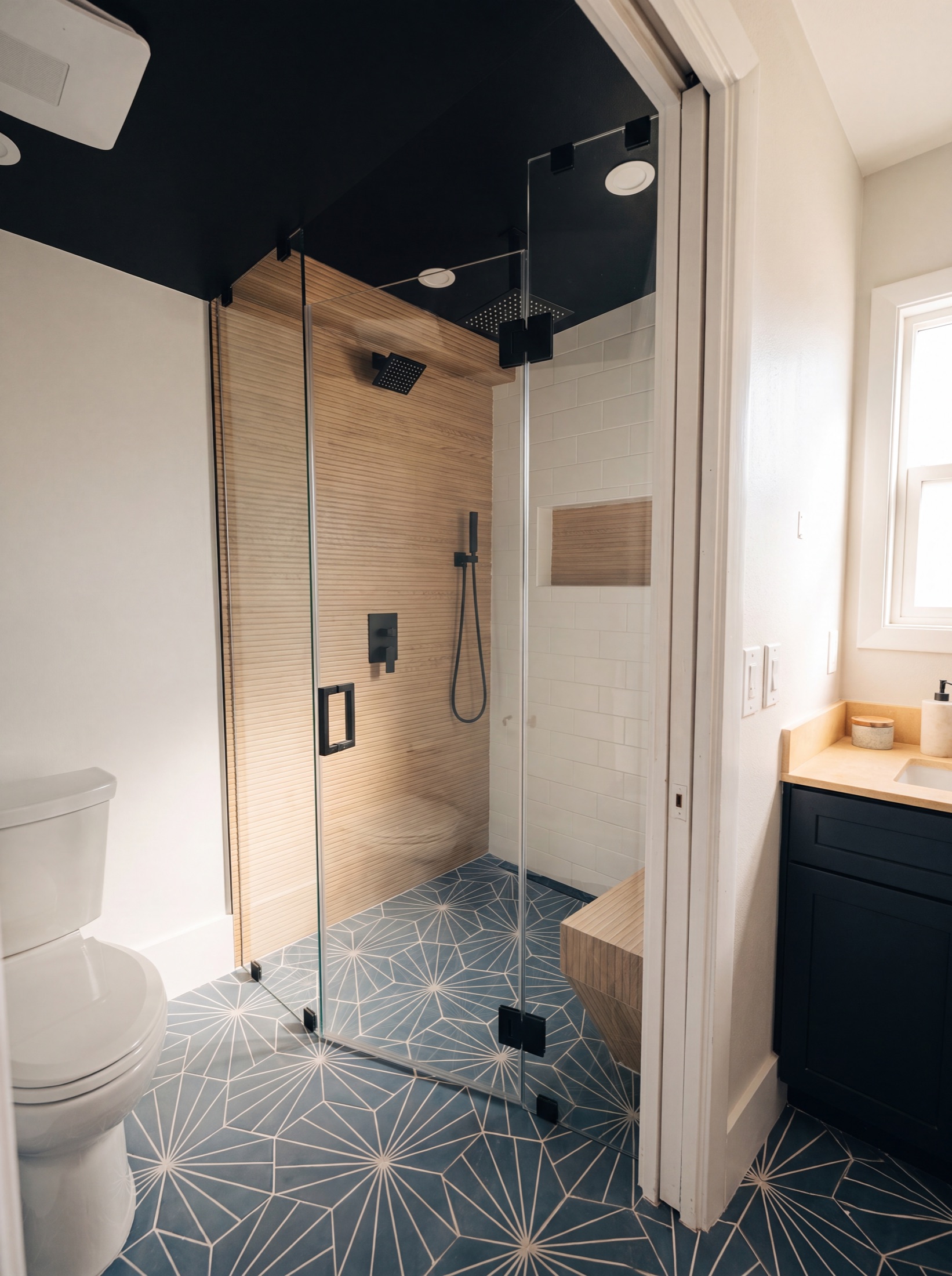 Bath after — walk-in shower with matte-black fixtures and patterned floor